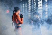 Duas pessoas fantasiadas fazem poses de artes marciais em uma cena dramática.