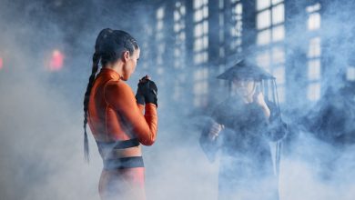 Duas pessoas fantasiadas fazem poses de artes marciais em uma cena dramática.