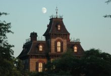 Mansão vitoriana sob o céu crepuscular, com a Lua visível ao fundo.