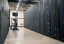 Racks metálicos com servidores, equipamentos de rede e cabos em um data center moderno.