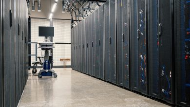 Racks metálicos com servidores, equipamentos de rede e cabos em um data center moderno.